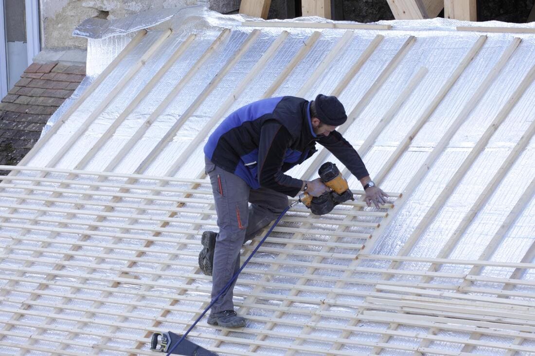 Worker on reflective flat-roof insulation